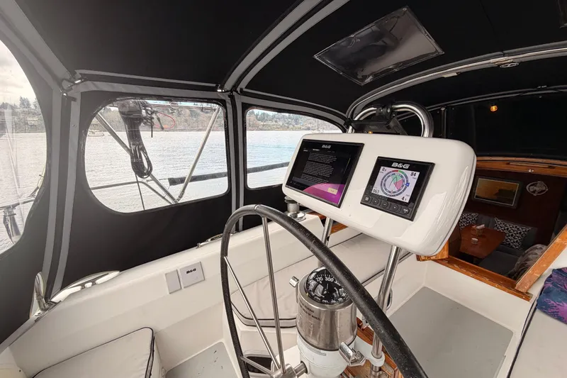 Slide: The Image of Cockpit of 1989 Catalina 42 sailboat with modern navigation equipment and scenic water view. - 19