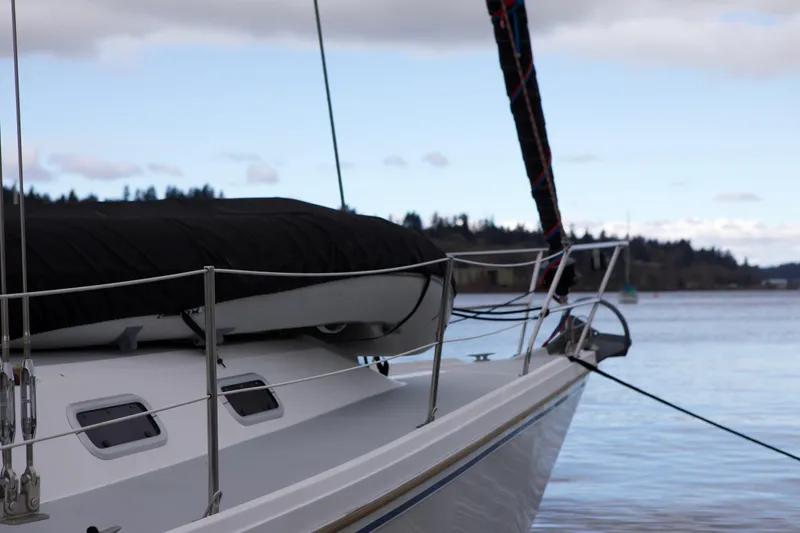 Slide: The Image of 1989 Catalina 42 sailboat docked on calm waters under a cloudy sky. - 2