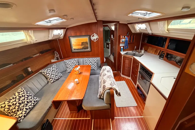Slide: The Image of Interior of a 1989 Catalina 42 sailboat with cozy seating and a compact kitchen. - 25