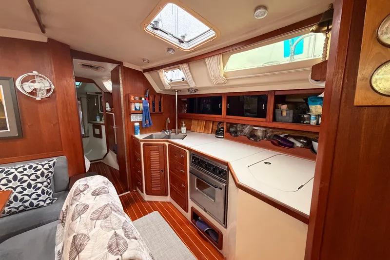 Slide: The Image of Interior of a 1989 Catalina 42 sailboat featuring a cozy kitchen and seating area. - 27