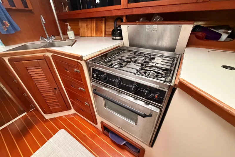 Slide: The Image of Galley kitchen in 1989 Catalina 42 sailboat with stove and wooden cabinetry. - 28