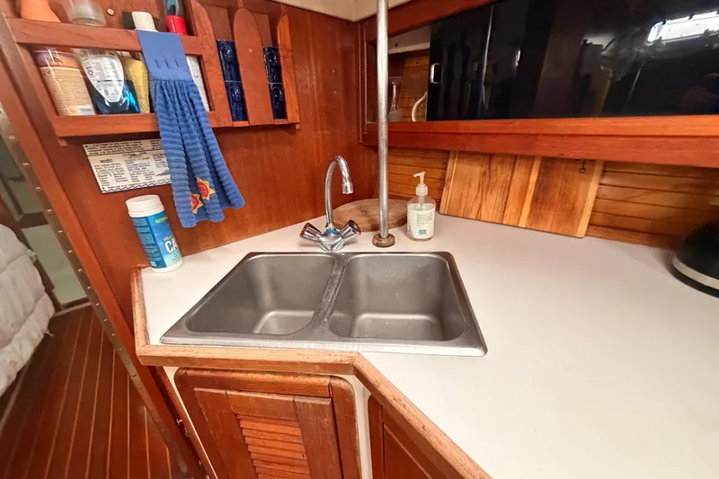 Slide: The Image of Galley sink area in 1989 Catalina 42 sailboat with wooden cabinetry and countertop. - 29