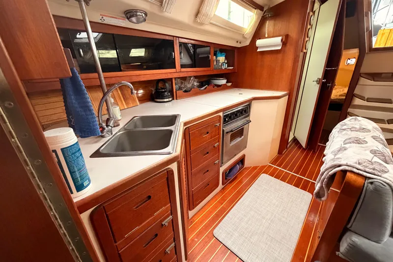Slide: The Image of Interior of a 1989 Catalina 42 sailboat kitchen with wooden cabinetry and dual sinks. - 30