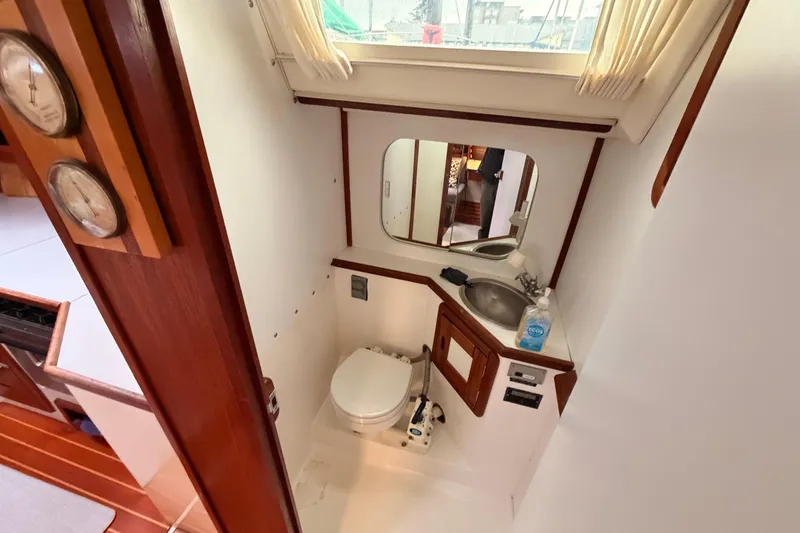 Slide: The Image of 1989 Catalina 42 yacht bathroom with sink, toilet, and mirror. - 32