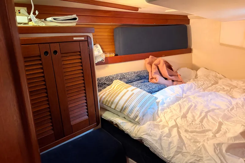 Slide: The Image of Cozy cabin interior of 1989 Catalina 42 sailboat with bed and wooden storage. - 33
