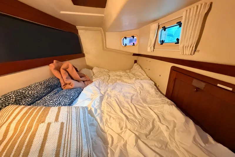 Slide: The Image of Cozy cabin interior of 1989 Catalina 42 sailboat with bed and porthole windows. - 34