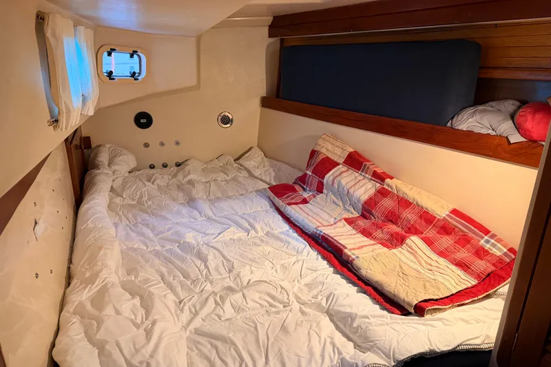 Slide: The Image of Cozy cabin interior of a 1989 Catalina 42 sailboat with a neatly made bed. - 36