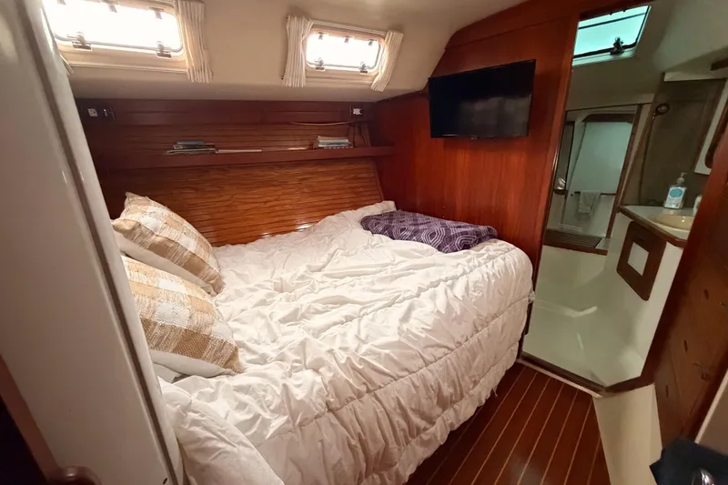 Slide: The Image of Cozy cabin interior of 1989 Catalina 42 sailboat with bed, TV, and wooden accents. - 37