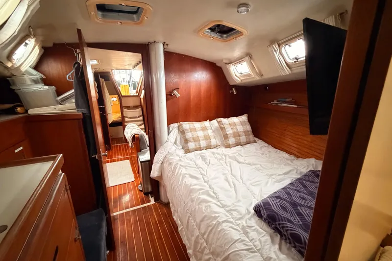 Slide: The Image of Cozy cabin interior of 1989 Catalina 42 sailboat with wood paneling and comfortable bedding. - 42