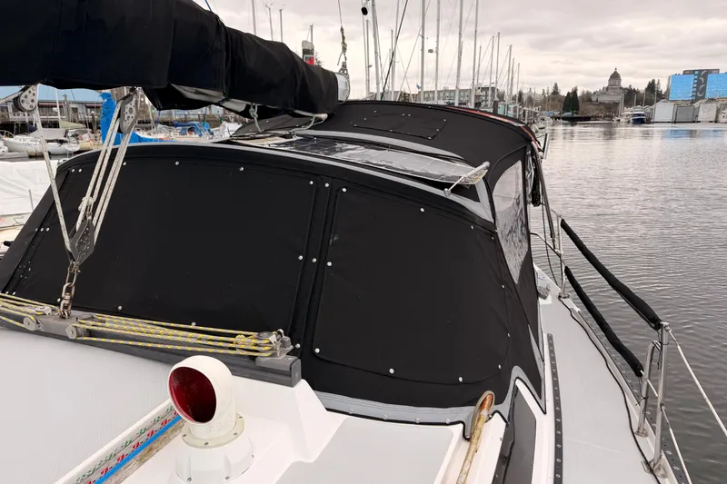 Slide: The Image of 1989 Catalina 42 sailboat docked, featuring black canvas cover and rigging details. - 6