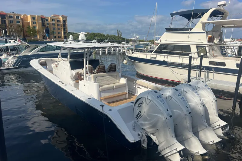 Slide: The Image of 2025 Jupiter 43 boat with four Yamaha engines docked in a marina. - 13