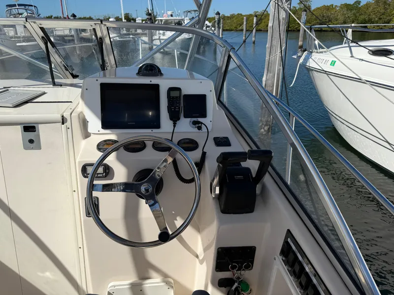 Slide: The Image of 2006 Cobia 250 Walk-Around boat dashboard with steering wheel and navigation equipment. - 11