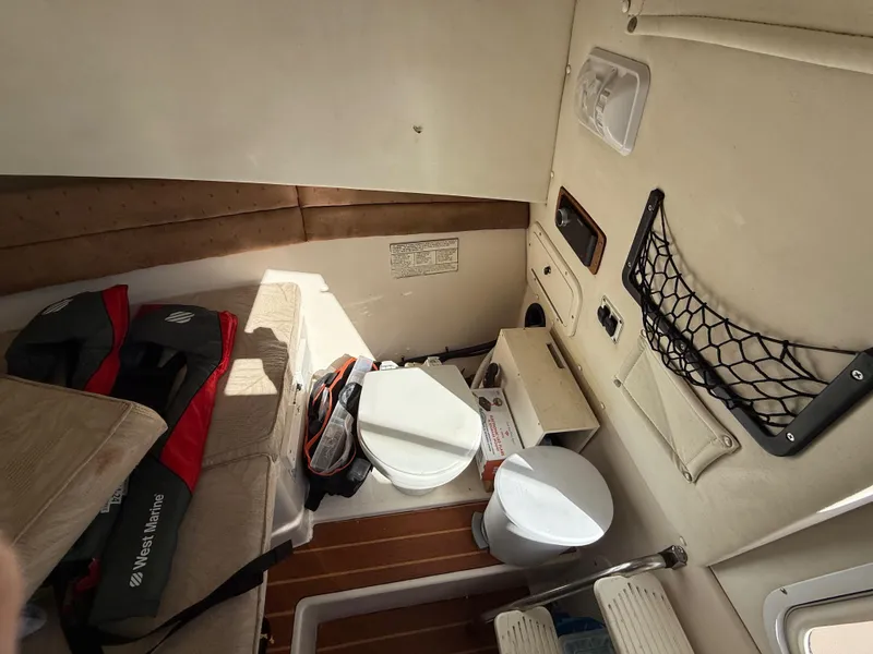 Slide: The Image of Interior cabin of 2006 Cobia 250 Walk-Around boat with seating and toilet. - 15