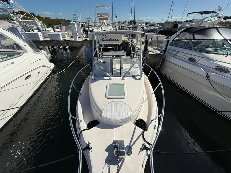 Slide: The Image of 2006 Cobia 250 Walk-Around boat docked at marina, surrounded by other vessels. - 5