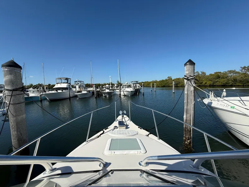 Slide: The Image of 2006 Cobia 250 Walk-Around boat docked in a marina under clear blue skies. - 6