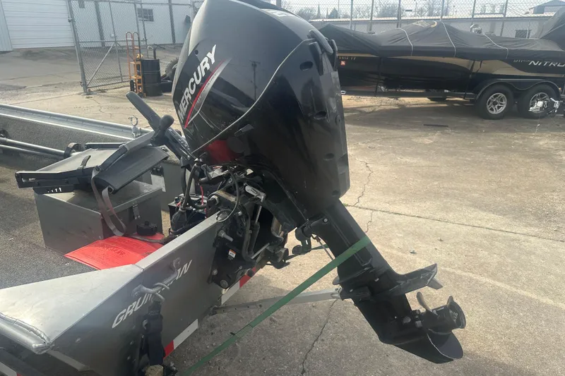 Slide: The Image of 1991 Grumman Rogue 150 T boat with Mercury outboard motor in a parking lot. - 10