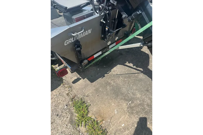 Slide: The Image of 1991 Grumman Rogue 150 T boat rear view with visible motor and trailer. - 16