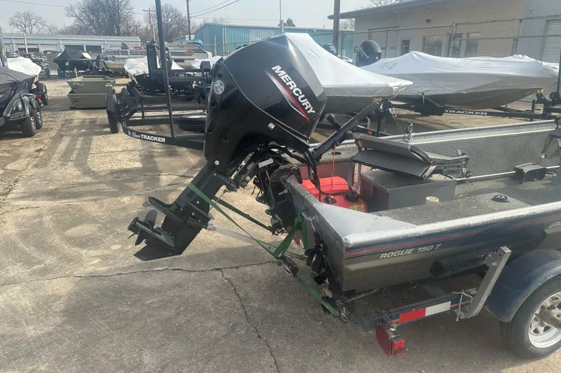 Slide: The Image of 1991 Grumman Rogue 150 T boat with Mercury outboard motor in a storage yard. - 4