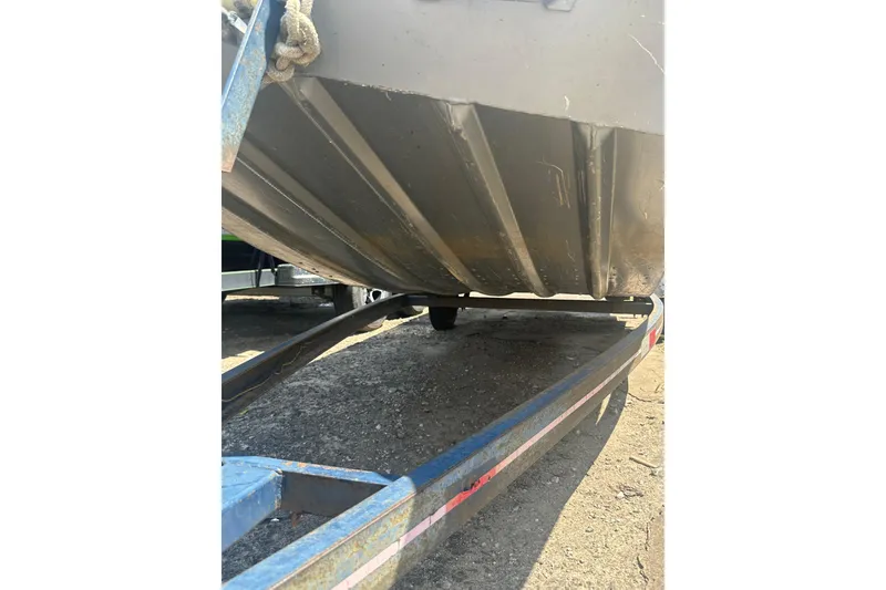 Slide: The Image of 1991 Grumman Rogue 150 T boat underside on trailer, showing hull and support structure. - 15