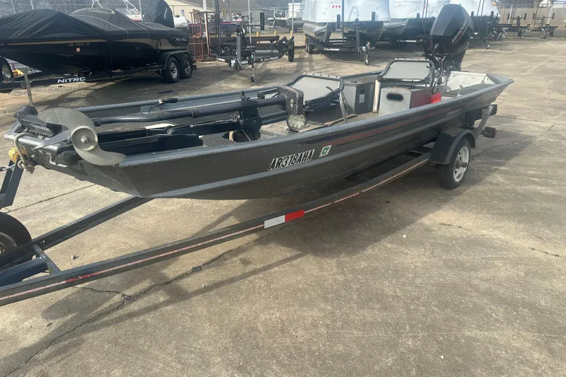 Slide: The Image of 1991 Grumman Rogue 150 T boat on trailer, parked outdoors. - 8