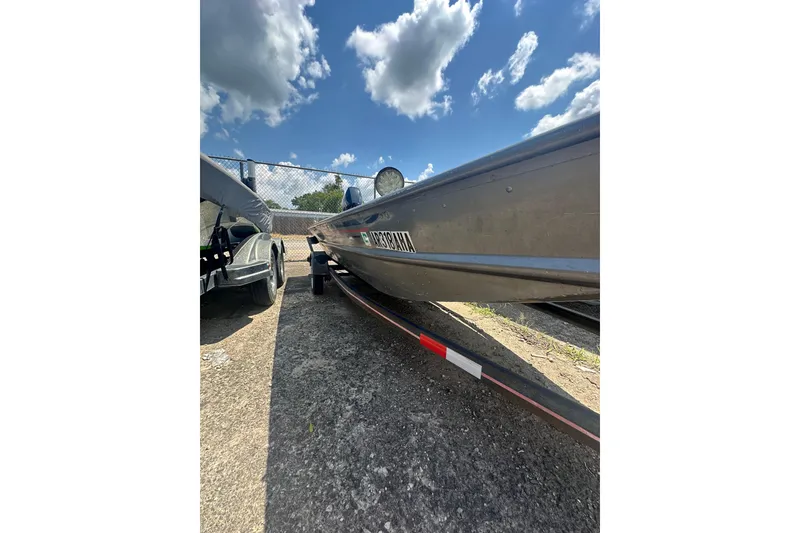 Slide: The Image of 1991 Grumman Rogue 150 T boat on trailer under blue sky with clouds. - 12