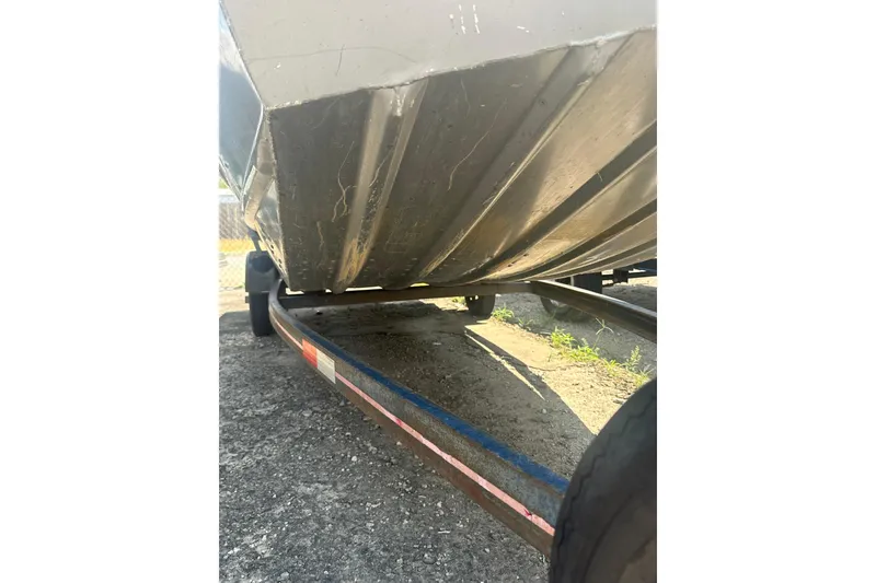 Slide: The Image of 1991 Grumman Rogue 150 T boat underside on trailer, showing hull details. - 13