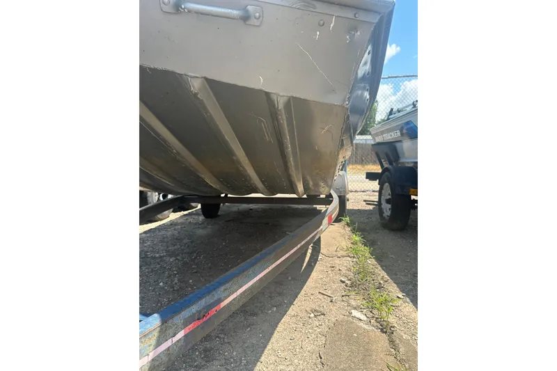 Slide: The Image of 1991 Grumman Rogue 150 T boat on trailer, showing hull and trailer details. - 14