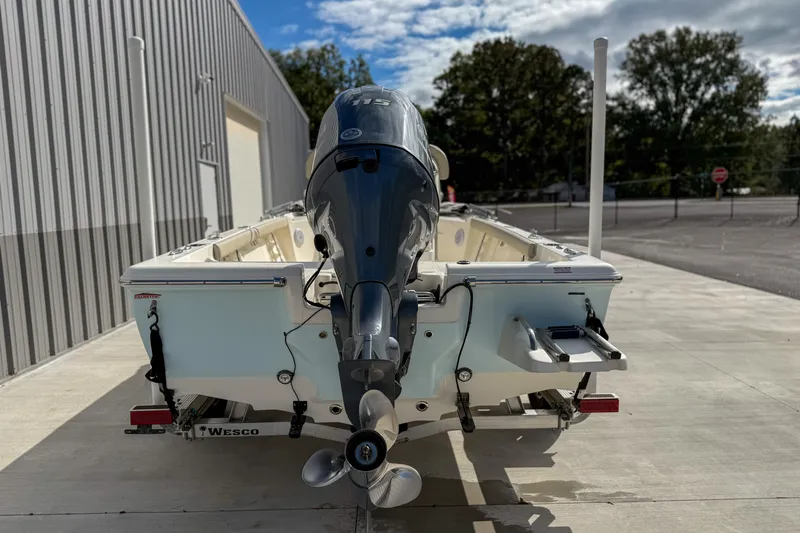 Slide: The Image of 2022 Key West 188 Bay Reef boat with outboard motor, parked on concrete near a building. - 7