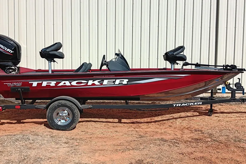 The Image of 2025 Tracker Pro Team 175 boat, red, on trailer, parked outdoors. - 0