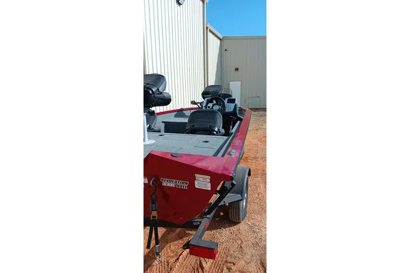 Slide: The Image of 2025 Tracker Pro Team 175 boat, red exterior, parked outdoors near a building. - 17