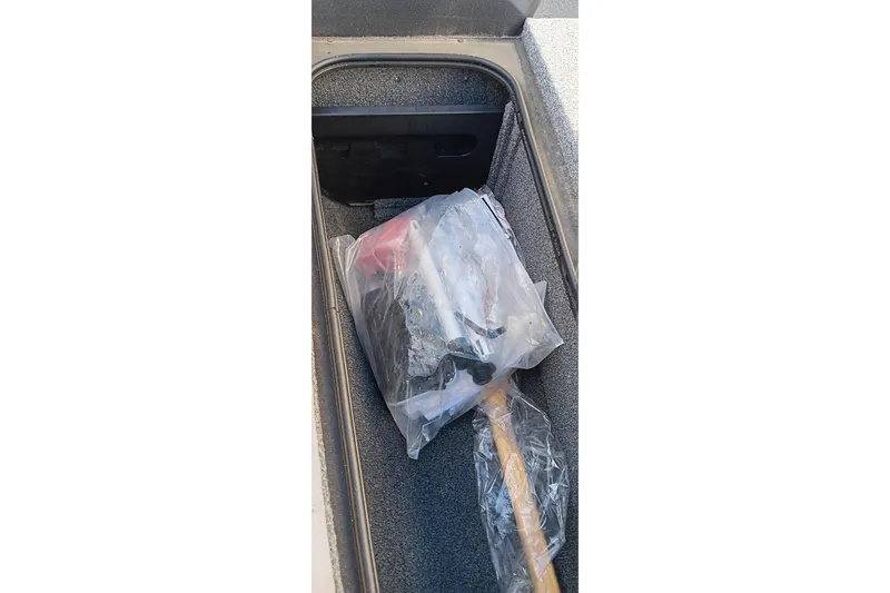 Slide: The Image of Storage compartment of 2025 Tracker Pro Team 175 boat with tools in plastic bag. - 20