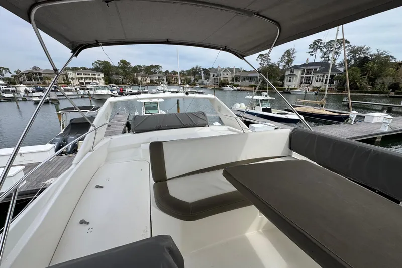 Slide: The Image of 2014 Prestige 400 yacht with spacious deck, docked in a scenic marina. - 11