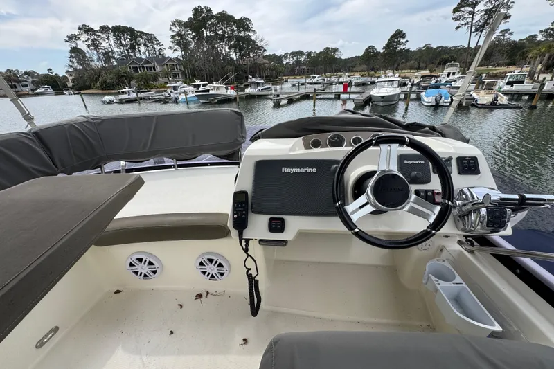 Slide: The Image of Helm of 2014 Prestige 400 yacht with Raymarine equipment, docked in a scenic marina. - 12
