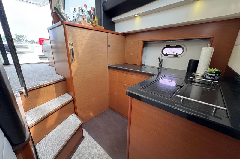 Slide: The Image of Luxurious 2014 Prestige 400 yacht kitchen with modern wood cabinetry and sleek black countertops. - 16
