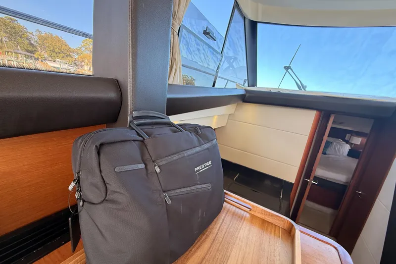 Slide: The Image of Interior of a 2014 Prestige 400 yacht with a black bag on a wooden surface. - 30