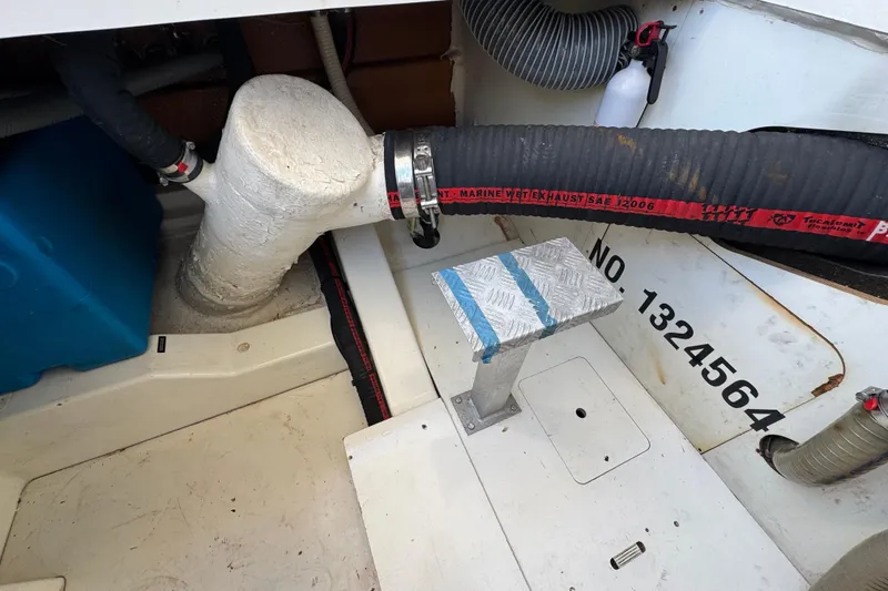 Slide: The Image of Engine compartment of a 2014 Prestige 400 boat, featuring exhaust hoses and metal platform. - 39
