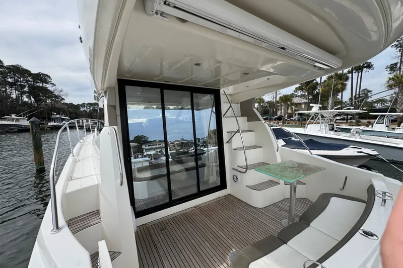 Slide: The Image of 2014 Prestige 400 yacht deck with seating, glass table, and marina view. - 4