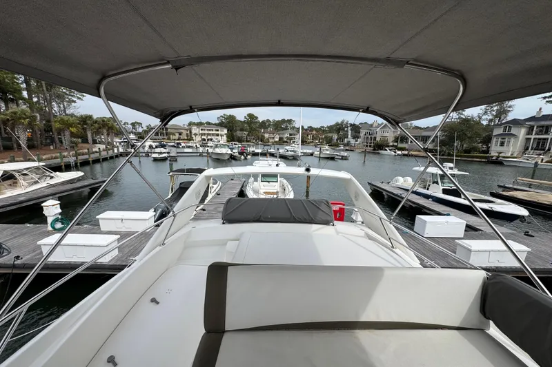 Slide: The Image of 2014 Prestige 400 yacht docked in a marina, surrounded by boats and waterfront homes. - 8