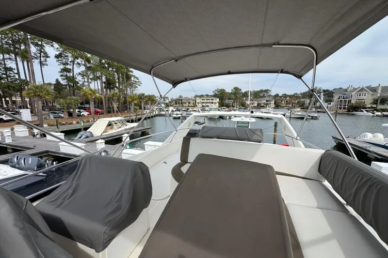 Slide: The Image of 2014 Prestige 400 yacht docked at marina, featuring spacious deck and canopy. - 9