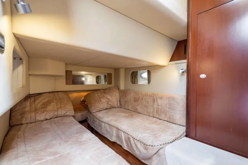 Slide: The Image of 2005 Sea Ray 420 Sedan Bridge cabin interior with cozy twin beds and wooden accents. - 10