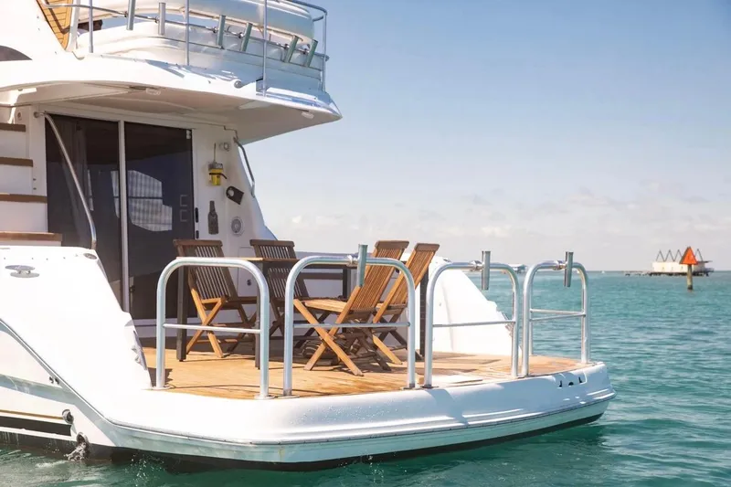 Slide: The Image of 2005 Sea Ray 420 Sedan Bridge yacht with deck chairs on calm water. - 2