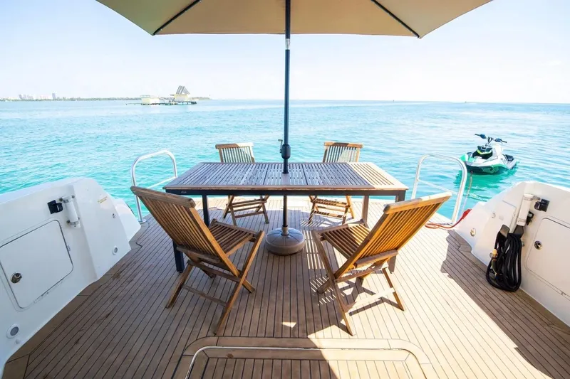 Slide: The Image of 2005 Sea Ray 420 Sedan Bridge yacht deck with chairs, table, and ocean view. - 4