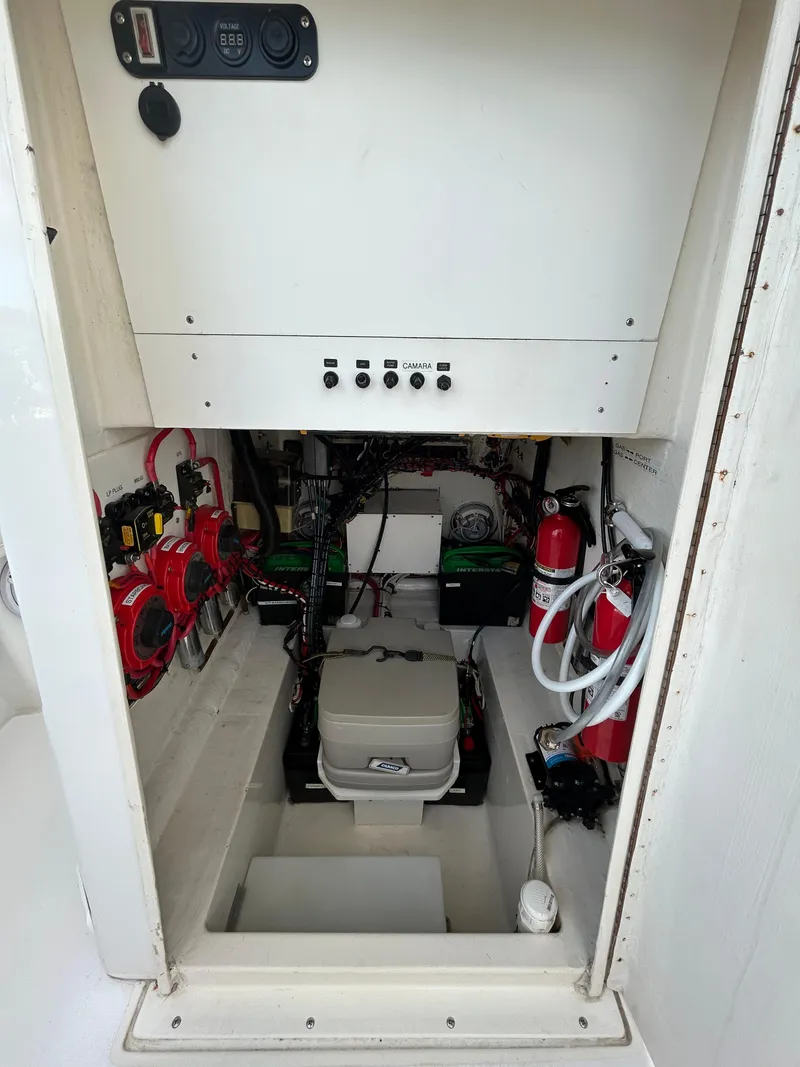 Slide: The Image of 2001 Contender 27' cuddy cabin interior with electrical components and fire extinguishers. - 10