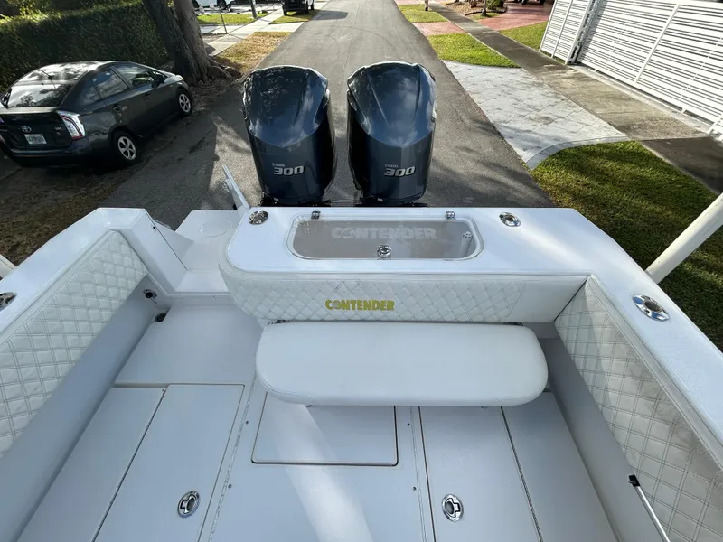 Slide: The Image of 2001 Contender 27' cuddy boat with twin 300 engines, parked on a driveway. - 6