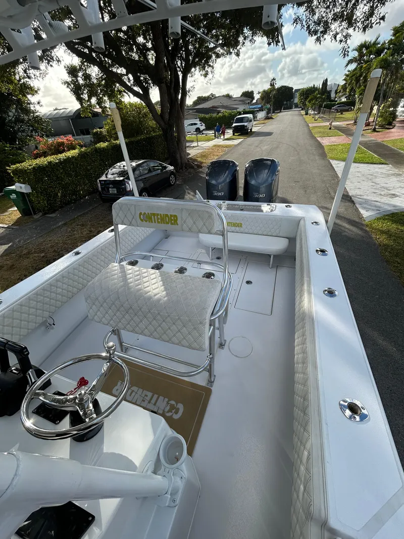 Slide: The Image of 2001 Contender 27' cuddy boat with dual engines, parked on a residential street. - 9