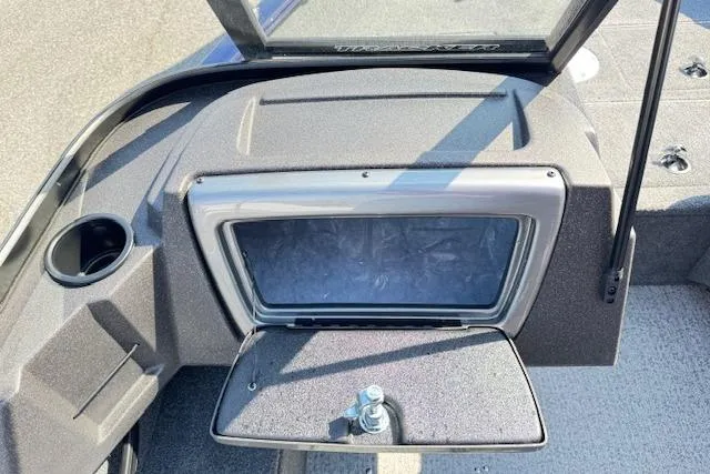 Slide: The Image of 2023 Tracker Pro Guide V-16 WT boat dashboard with storage compartment open. - 12