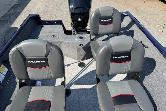 Slide: The Image of 2023 Tracker Pro Guide V-16 WT boat interior with three gray seats and motor. - 16