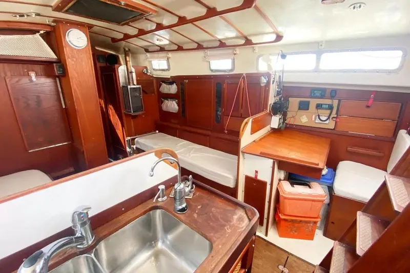 Slide: The Image of Interior of 1975 Whitby 42 Ketch sailboat with wood finishes and compact kitchen area. - 13