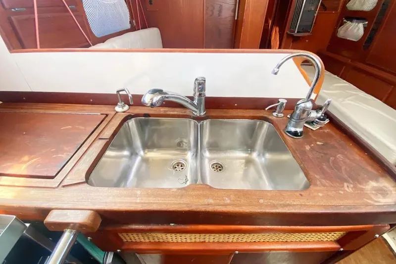 Slide: The Image of 1975 Whitby 42 Ketch kitchen sink with wooden countertop and dual faucets. - 14