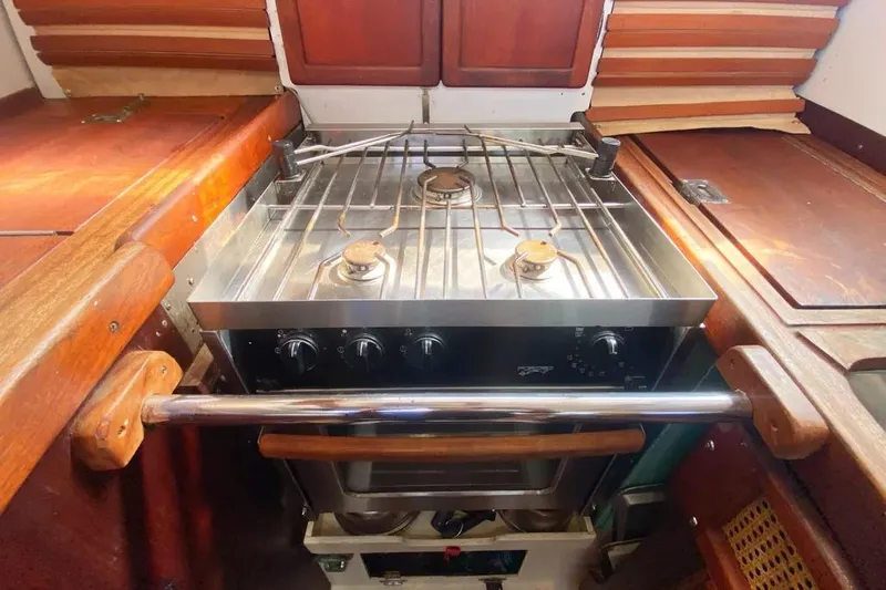 Slide: The Image of 1975 Whitby 42 Ketch galley with stainless steel stove and wooden cabinetry. - 15